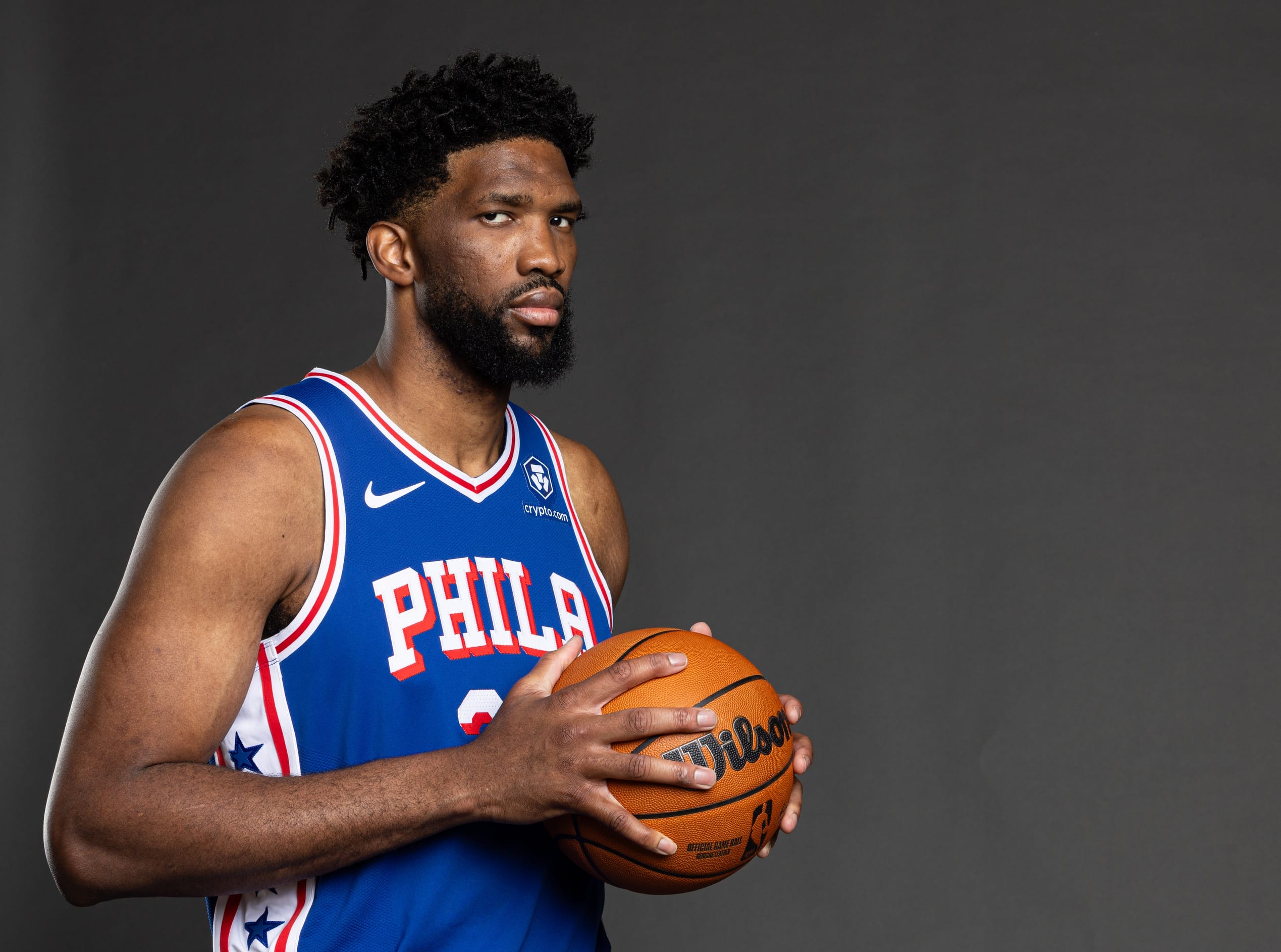 Joel Embiid holding a basketball.